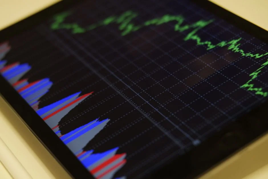 Team reviewing financial charts and digital data on tablets in an office setting.